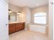 Main bathroom featuring dual sinks, tile flooring, and a soaking tub under a large window at 116 Hercules Dr, Rotonda West, FL 33947