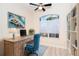 Cozy home office featuring a wooden desk, blue chair, natural light, and built-in bookshelves at 116 Hercules Dr, Rotonda West, FL 33947