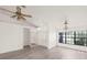 Bright living room featuring hardwood floors, ceiling fans, and a large window overlooking the yard at 3568 Middletown St, Port Charlotte, FL 33952