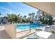 Inviting community pool area with lounge chairs and tables surrounded by lush landscaping on a sunny day at 4260 Placida Rd # 12C, Englewood, FL 34224