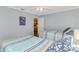 Bedroom with light blue walls and twin beds, with view into kitchen area at 5231 Conner Ter, Port Charlotte, FL 33981