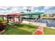 Waterfront property features a boat lift, dock, and lush landscaping, ideal for boating enthusiasts at 5231 Conner Ter, Port Charlotte, FL 33981