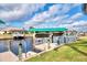 Waterfront view of dock with boat lift in backyard on the canal under a partly cloudy sky at 5231 Conner Ter, Port Charlotte, FL 33981