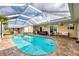 Inviting screened-in pool area with lounge seating and a hot tub, surrounded by lush landscaping at 5231 Conner Ter, Port Charlotte, FL 33981