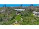 Aerial view of property featuring a walkway, house, gazebo and pool nestled within lush greenery at 7475 Manasota Key Rd, Englewood, FL 34223