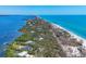 Breathtaking aerial view of a beautiful coastline with lush vegetation and serene blue waters at 7475 Manasota Key Rd, Englewood, FL 34223