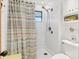 Bright bathroom with shower, attractive striped curtain, white tile and convenient built in storage at 7475 Manasota Key Rd, Englewood, FL 34223