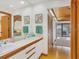 Bright bathroom features double sinks, wooden accents, and access to a balcony at 7475 Manasota Key Rd, Englewood, FL 34223