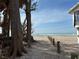 Picturesque beachfront with white sand, clear water, and a charming wooden fence at 7475 Manasota Key Rd, Englewood, FL 34223