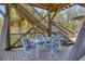 Charming covered deck with seating, surrounded by lush greenery and the unique wooden framework at 7475 Manasota Key Rd, Englewood, FL 34223