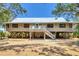 Charming stilt home with a metal roof and inviting balcony, perfect for enjoying coastal breezes at 7475 Manasota Key Rd, Englewood, FL 34223