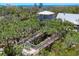 Unique home exterior featuring elevated walkways and a gazebo nestled in lush greenery at 7475 Manasota Key Rd, Englewood, FL 34223