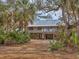 Inviting stilt home nestled amongst mature trees and landscaping for ultimate privacy at 7475 Manasota Key Rd, Englewood, FL 34223