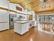 Open kitchen features stainless steel appliances, an island, wood ceiling and adjacent dining area at 7475 Manasota Key Rd, Englewood, FL 34223