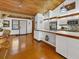 Bright kitchen with white cabinets, stainless steel appliances, and wood floors, combining style and functionality at 7475 Manasota Key Rd, Englewood, FL 34223
