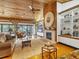 Bright living room with a fireplace, wood ceilings, and large windows offering scenic views at 7475 Manasota Key Rd, Englewood, FL 34223