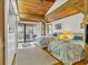 Bright main bedroom with vaulted wood ceiling, closet with mirrored doors, and private balcony access at 7475 Manasota Key Rd, Englewood, FL 34223