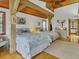 Airy main bedroom showcasing beautiful hardwood floors and a vaulted ceiling with rustic beam accents at 7475 Manasota Key Rd, Englewood, FL 34223