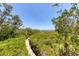 Scenic wooden walkway through lush green landscape with ocean view at 7475 Manasota Key Rd, Englewood, FL 34223