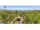Elevated wooden walkway through lush greenery, leading to scenic water views for tranquil access to the waterfront at 7475 Manasota Key Rd, Englewood, FL 34223