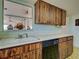 Functional kitchen space showcasing wood cabinets, a sink, and a dishwasher for convenience at 914 E 2Nd St, Englewood, FL 34223