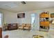 Cozy living room featuring vintage furniture, carpet, and a decorative shelving unit at 914 E 2Nd St, Englewood, FL 34223
