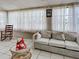 Sunroom with tile floors, many windows, white curtains, and a comfortable sofa at 914 E 2Nd St, Englewood, FL 34223