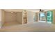Bright living room with ceiling fan, wet bar, and sliding glass doors leading to a screened patio at 10045 Links Ln # 203, Rotonda West, FL 33947