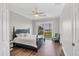 Bright bedroom showcasing a queen bed, wood floors, ceiling fan, and balcony overlooking a lake view at 10360 Longshore Rd # 66, Placida, FL 33946