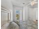 Bright bedroom featuring a queen bed and access to a balcony overlooking neighborhood street at 10360 Longshore Rd # 66, Placida, FL 33946