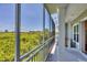 Screened-in patio with views of lush greenery and nearby buildings in the distance at 10360 Longshore Rd # 66, Placida, FL 33946