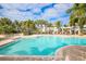 Bright community pool with tanning deck, and tropical landscaping surrounding the area for privacy at 10360 Longshore Rd # 66, Placida, FL 33946