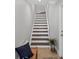 Bright staircase featuring stained wood steps, white risers, and a white handrail at 10360 Longshore Rd # 66, Placida, FL 33946
