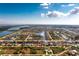 Aerial view of a waterfront home with a boat dock in a coastal community on a sunny day at 15626 Meacham Cir, Port Charlotte, FL 33981