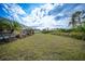 Manicured backyard with tropical foliage and view of the screened pool at 215 Australian Dr, Rotonda West, FL 33947