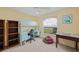 Bright bedroom featuring built-in desk with hutch, ceiling fan, and a view of the backyard at 215 Australian Dr, Rotonda West, FL 33947