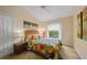 Comfortable bedroom with vibrant quilt, ceiling fan, and soft natural light from the window at 215 Australian Dr, Rotonda West, FL 33947
