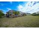 View of the backyard of the house featuring an enclosed pool with mature tropical landscaping at 215 Australian Dr, Rotonda West, FL 33947