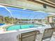 Relaxing screened-in pool area with tranquil lake view and comfortable lounge seating, perfect for outdoor enjoyment at 252 Medalist Rd, Rotonda West, FL 33947