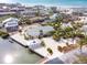 An aerial view of a light pink, two-story waterfront house surrounded by a gravel yard and palm trees at 2805 N Beach Rd # B, Englewood, FL 34223