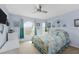 Sunlit bedroom featuring a unique arched window, ceiling fan, and tropical-themed bedding at 2805 N Beach Rd # B, Englewood, FL 34223
