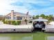 Beautiful waterfront home featuring a boat lift, dock, and landscaped yard with palm trees at 2805 N Beach Rd # B, Englewood, FL 34223