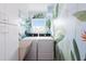 Well-lit laundry room with washer, dryer, sink, and tropical themed mural at 2805 N Beach Rd # B, Englewood, FL 34223