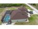 Backyard aerial view highlighting the screened-in pool and luxurious outdoor space with meticulous landscaping at 10451 Hatchett Cir, Port Charlotte, FL 33981