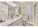 Well-lit bathroom with granite countertop, white cabinetry, tiled shower, and modern fixtures at 1061 Boundary Blvd, Rotonda West, FL 33947