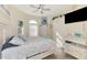 Comfortable bedroom with a ceiling fan, television, shutters, and an abundance of natural light at 1061 Boundary Blvd, Rotonda West, FL 33947