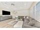 Bright living room boasts a tray ceiling, shutters and a large sectional sofa at 1061 Boundary Blvd, Rotonda West, FL 33947
