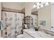 The bathroom has a granite countertop, a large mirror, and a shower with seashell curtains at 108 Wagon Place, Rotonda West, FL 33947