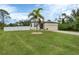 Inviting home with a lush green lawn, well-manicured landscape, and a two car attached garage at 108 Wagon Place, Rotonda West, FL 33947