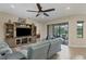Comfortable living room featuring a large TV, ceiling fan, and access to an outdoor patio at 108 Wagon Place, Rotonda West, FL 33947